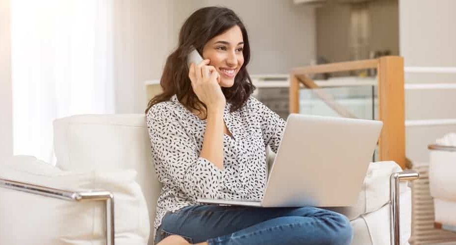 Frau-sitzt-auf-Sofa-mit-Telefon-und-Laptop